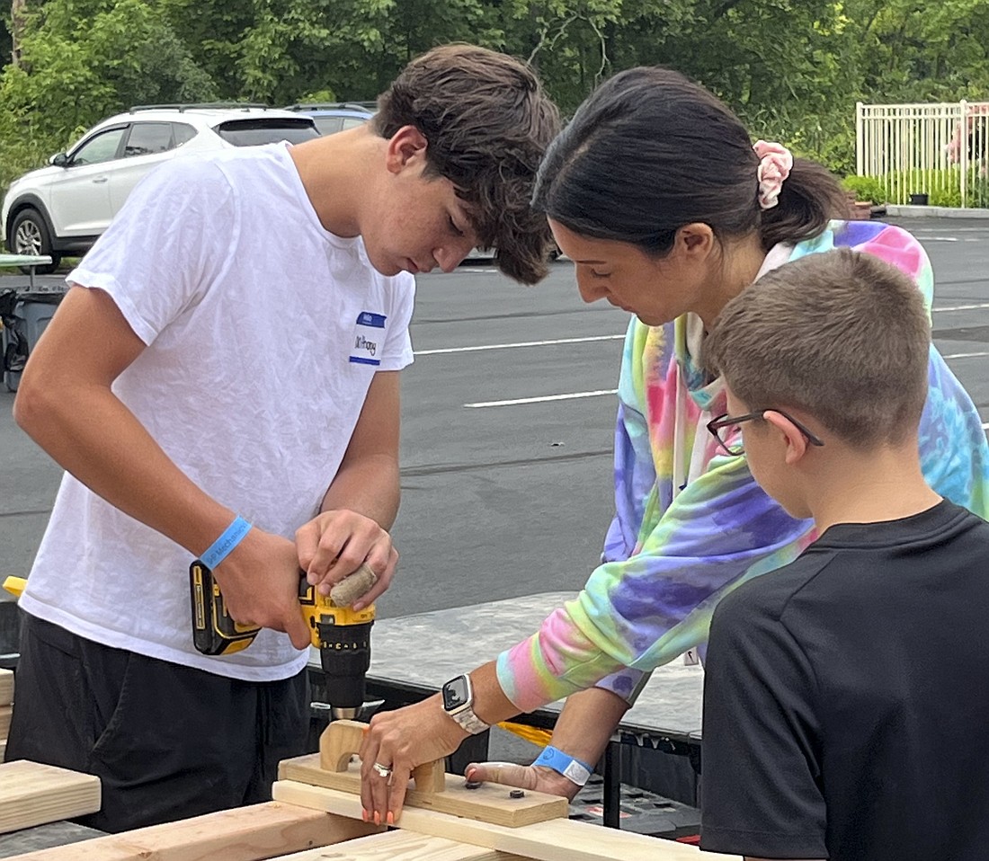 Volunteers help drill beds together as part of St. Michael the Archangel's third annual Bed Building day. (Provided photo)