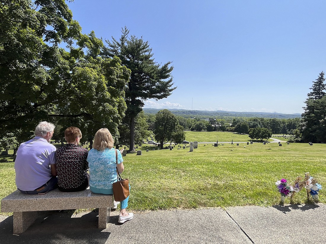 Loved ones attending the 2024 Anatomical Gift Program Memorial Service at St. Agnes Cemetery in Menands watch from the mausoleum’s bench as the urn of their loved one is buried in its final resting place. Six individuals were honored this year: Patricia F. Cole, Melba D. Cribbs, Lorraine C. Hoyt, Theresa F. Ippolito, Mary V. Mikrut, and James V. Murray. (Emily Benson photo)