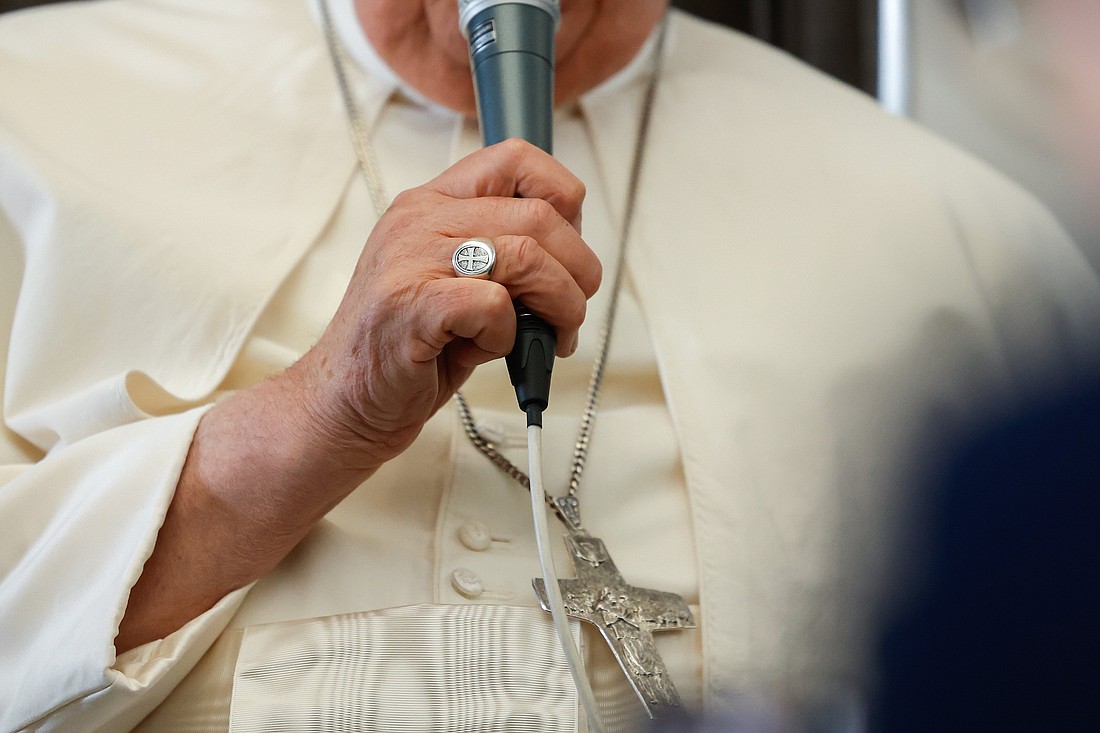 With his papal ring and pectoral cross visible, Pope Francis holds a microphone during a news conference aboard his flight back to Rome Sept. 13, 2024, after visiting Indonesia, Papua New Guinea, Timor-Leste and Singapore. It was his 45th and longest foreign trip. (CNS photo/Lola Gomez)