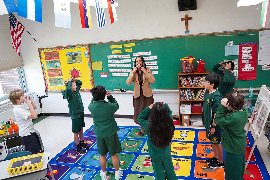 Spanish teacher Maria Soledad Pauli, center, leads fifth graders in a singing game as they learn the Spanish words for body parts on Sept. 11 at Mater Christi School in Albany. (Cindy Schultz photo for The Evangelist)