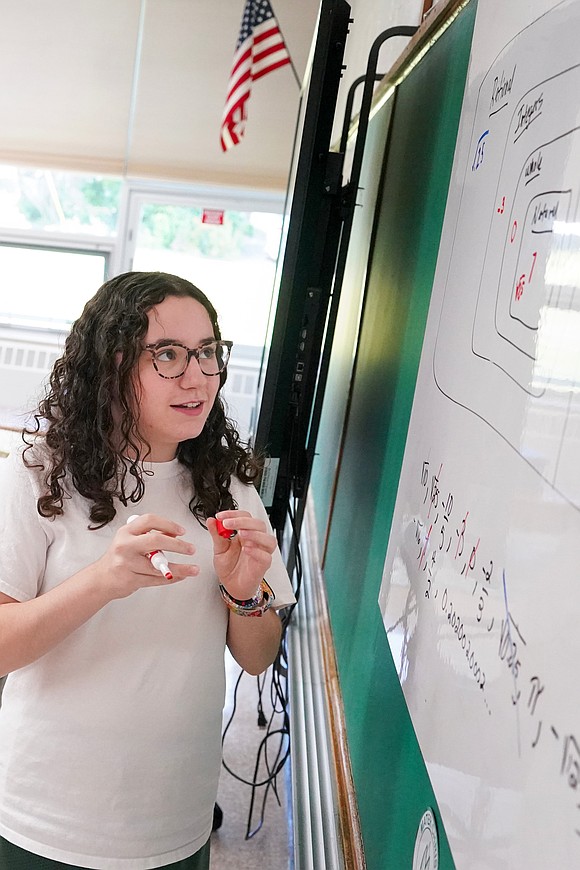 Sonia Parr goes to the white board to work out an Algebra problem in her eighth-grade math class on Sept. 11 at Mater Christi School in Albany. (Cindy Schultz photo for The Evangelist)