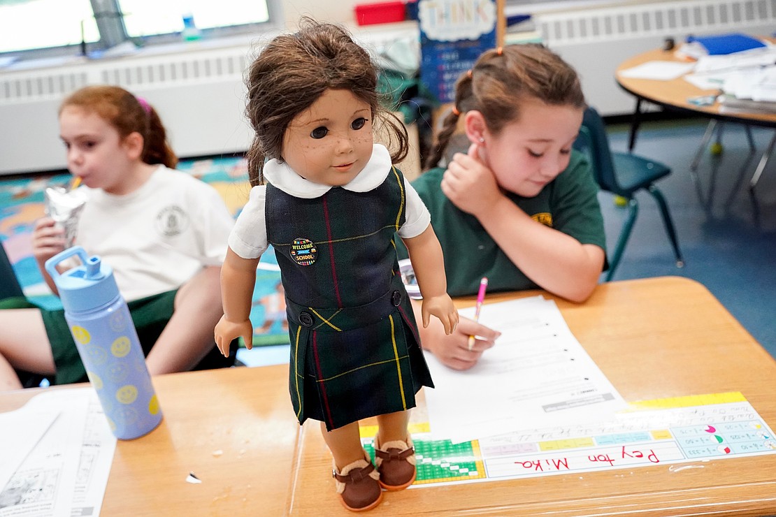 Peyton Mika (r.) keeps her doll, named Mini Peyton, on her desk in third-grade class on Sept. 11 at Mater Christi School in Albany. (Cindy Schultz photo for The Evangelist)