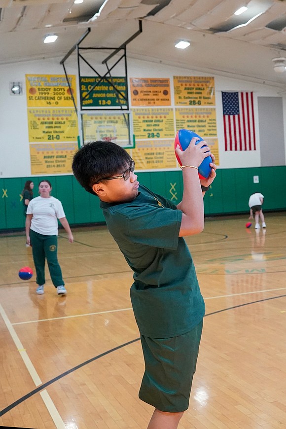 Javen Nathaniel Bejo catches a football while warming up for eighth-grade gym class on Sept. 11 at Mater Christi School in Albany. (Cindy Schultz photo for The Evangelist)