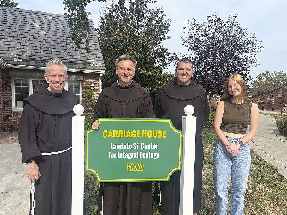 Brother Michael Perry, OFM, (from l.) director of the Laudato Si’ Center for Integral Ecology at Siena College, is shown with Brother Jacek Orzechowski, OFM, associate director, Brother Jimmy Kernan, assistant director, and Emma Andros, a junior and environmental studies major at Siena. (Emily Benson photo)