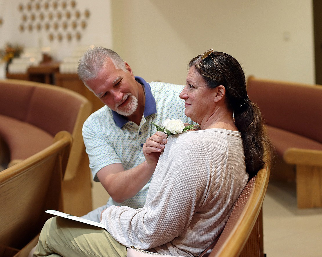 David Zon pins a flower on his wife of 25 years, Stacey, before the 52nd Annual Marriage Jubilee Celebration at Christ Our Light Church in Loudonville on Sept. 29. The Zons, of Greenfield Center, have been married 25 years. (Tom Killips photo)