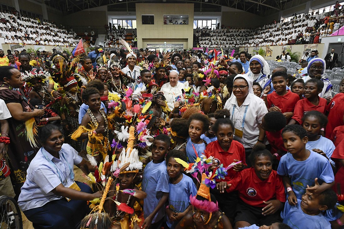 Pope Francis, shown taking a photo with children at the Caritas Technical Secondary School in Port Moresby, Papua New Guinea last month, said during his message for World Mission Sunday that “the mission for all requires the commitment of all. We need to continue our journey toward a fully synodal and missionary Church in the service of the Gospel.” (CNS photo/Vatican Media)