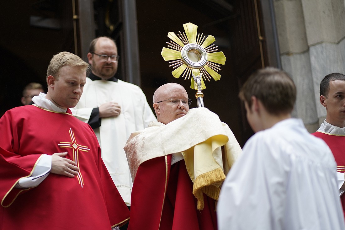 Father Roger Landry, chaplain for the National Eucharistic Pilgrimage, carries a monstrance from St. Mary’s Church in New Haven, Conn., at the start of a Eucharistic procession on May 18. Father Landry was recently named national director of the Pontifical Mission Societies USA. (OSV News photo)