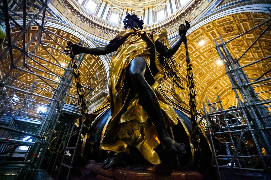 A statue of an angel, draped in gold, is seen surrounded by scaffolding during restoration work on the 17th-century canopy standing over the main altar of St. Peter’s Basilica at the Vatican Oct. 8, 2024. (CNS photo/Lola Gomez)