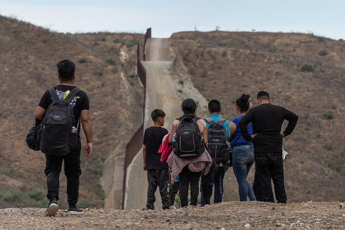 The Border Wall is seen in the background as migrants from South and Central America look to surrender to immigration officials after crossing into the United States from Mexico in Ruby, Arizona, June 24, 2024. (OSV News photo/Adrees Latif, Reuters)