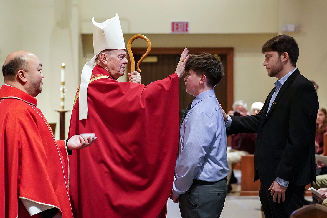 Bishop Edward B. Scharfenberger anoints Jack McCarthy of Sacred Heart during confirmation on Nov. 23 at the Church of the Holy Spirit in East Greenbush. (Cindy Schultz photo for The Evangelist)