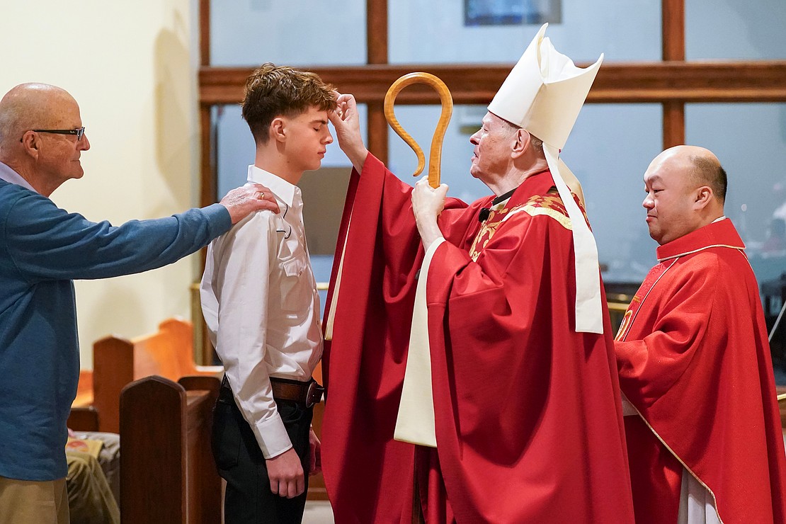 Bishop Edward B. Scharfenberger anoints Gunnar Gibbons of Sacred Heart during confirmation on Saturday, Nov. 23, 2024, at Church of the Holy Spirit in East Greenbush, N.Y.  Cindy Schultz for The Evangelist