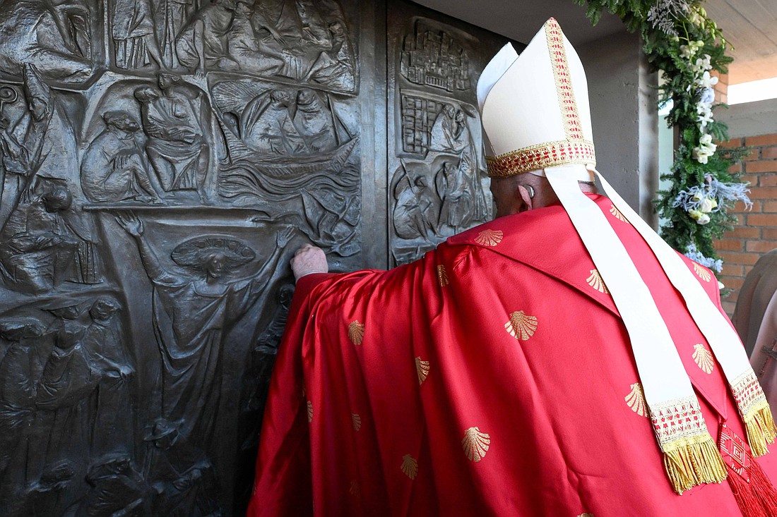 Pope Francis knocks on the Holy Door of the Church of Our Father at Rome's Rebibbia prison Dec. 26, 2024, before opening it and presiding over a Mass with inmates, prison staff and Italian government officials. (CNS photo/Vatican Media)