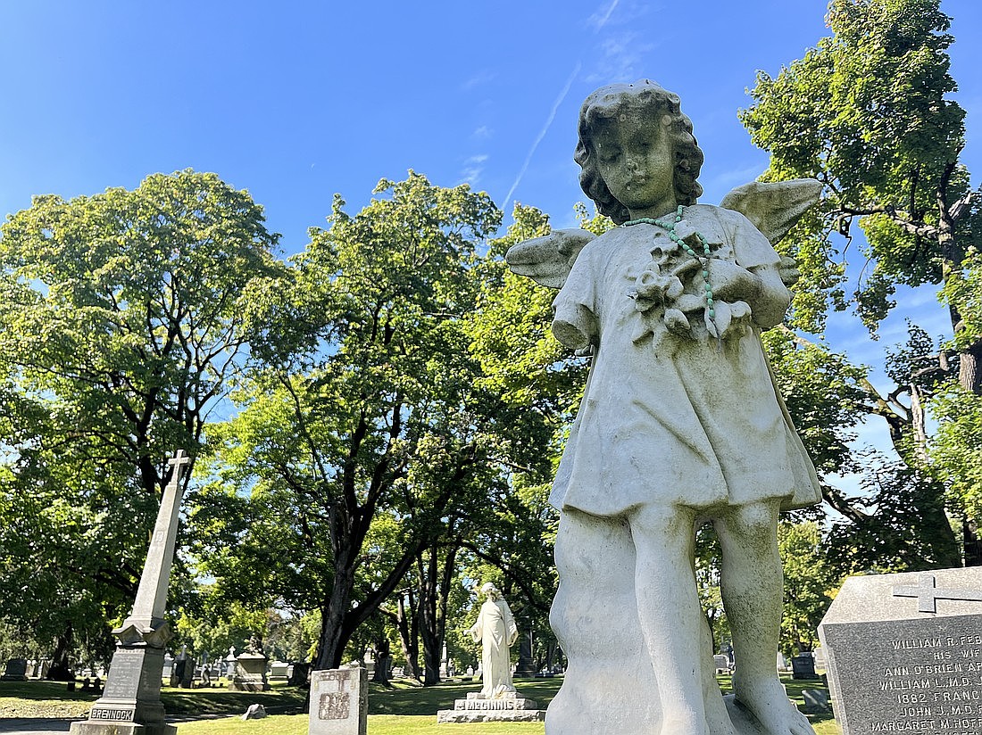 An angel statue (from l.) marks the grave of 8-year-old Loretta inside St. Agnes Cemetery in Menands. The statue is one of many interesting stops along the St. Agnes tour, which Kelly Grimaldi, Director for Education and Program Development for Albany Diocesan Cemeteries, led staff writer Emily Benson on in October. (Emily Benson photo)