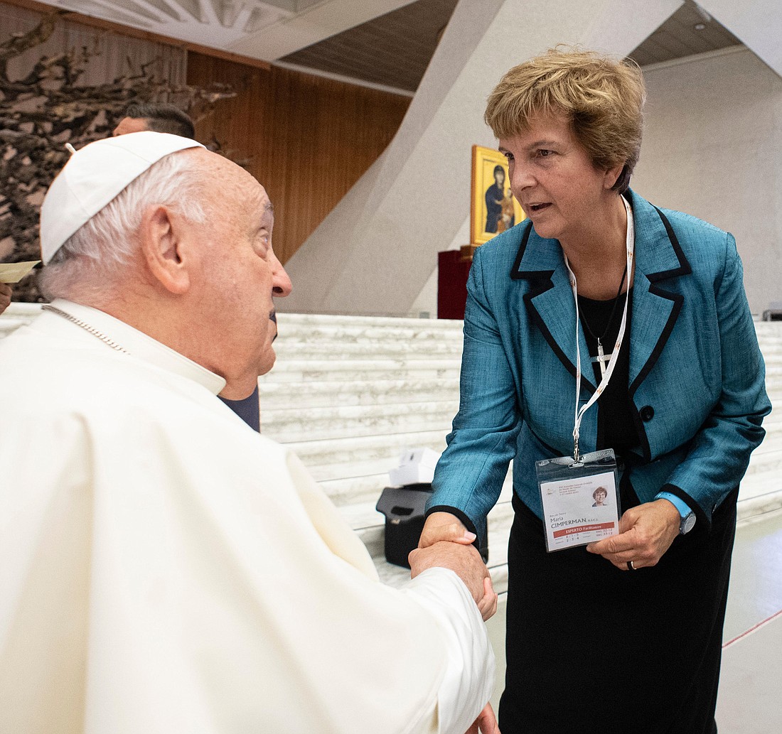 Pope Francis greets synod delegates Sister Maria Cimperman, RSCJ, before a working session of the Synod of Bishops on synodality at the Vatican on Oct. 4, 2024. (CNS photo/ Vatican Media)