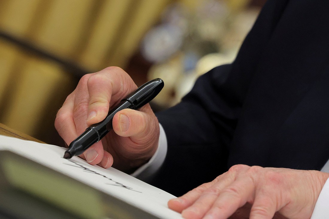 U.S. President Donald Trump signs documents in the Oval Office at the White House on Inauguration Day in Washington Jan. 20, 2025. He signed a series of executive orders including on immigration, birthright citizenship and climate. Trump also signed an executive order granting about 1,500 pardons for those charged in connection with the Jan. 6, 2021, riot at the U.S. Capitol. (OSV News photo/Carlos Barria, Reuters)