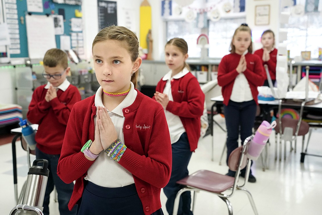 Lillian Sharp, center, joins her third-grade class in morning prayers on Jan. 16 at Holy Spirit School in East Greenbush. (Cindy Schultz photo for The Evangelist)