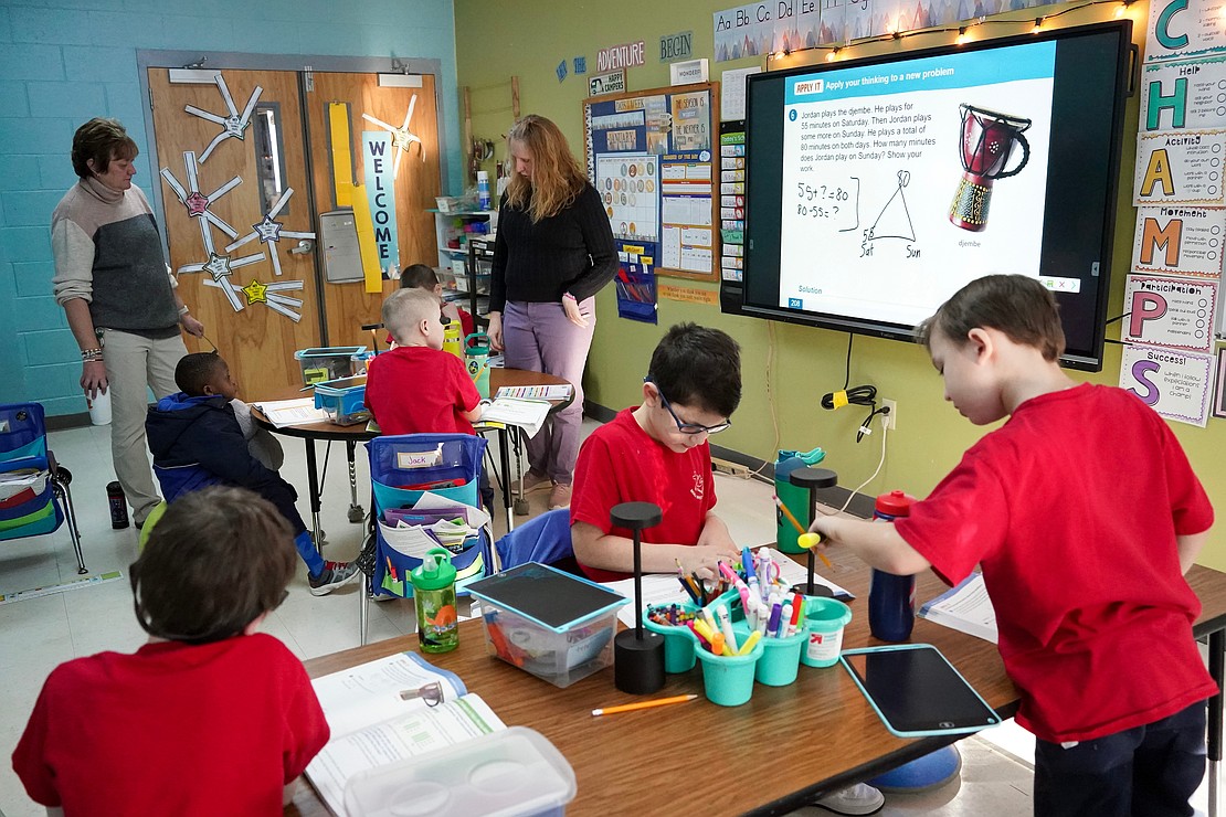 Principal Kelly Leverone, left, visits Connie Gicewicz’s second-grade class while they work on math problems  =on Jan. 16 at Holy Spirit School in East Greenbush. (Cindy Schultz photo for The Evangelist)