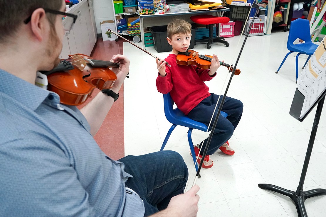 First grader Joel Gibson-Cook takes a violin lesson with instrumental music teacher Kevin Carey on Jan. 16 at Holy Spirit School in East Greenbush. (Cindy Schultz photo for The Evangelist)