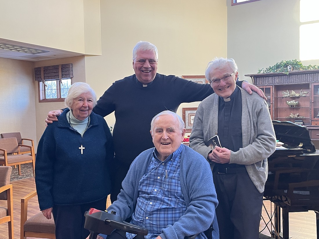 Sister Meg Canty, RSCJ, (from, l.), Father Robert Longobucco, Vicar General, Father Leo O'Brien and Father James Kane, diocesan director of Ecumenical and Interreligious Affairs, gather together after the Christian Unity Service at the Avila Retirement Community. (Emily Benson photos)