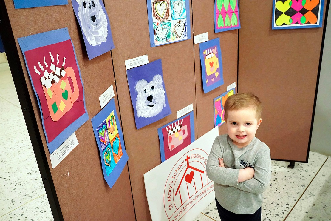 Benjamin Preston, 4, a Pre-K student at St. Mary’s School in Ballston Spa, stands by his polar bear artwork (c.) which is part of the Catholic Schools Week Art Exhibit at the Empire State Plaza South Concourse in Albany. (Cindy Schultz photo for The Evangelist)