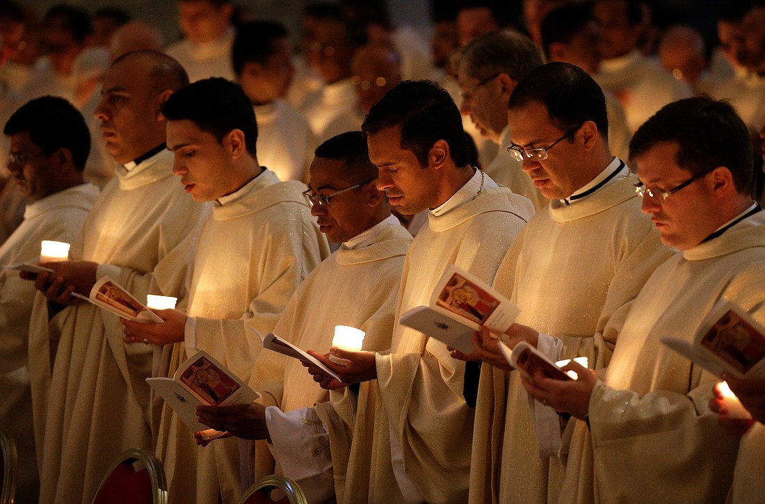 Priests hold candles as they wait for Pope Francis to arrive for Mass with consecrated women and men marking the feast of the Presentation of the Lord and the World Day for Consecrated Life in St. Peter's Basilica in this file photo. (CNS photo)
