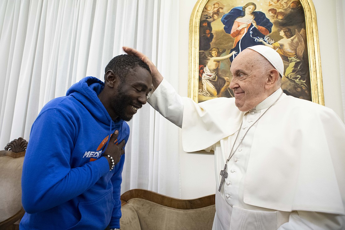 Pope Francis blesses Mbengue Nyimbilo Crepin, a migrant from Cameroon whose wife and daughter died in July crossing the North African desert, during a meeting in the Domus Sanctae Marthae at the Vatican Nov. 17, 2023. (CNS photo/Vatican Media)