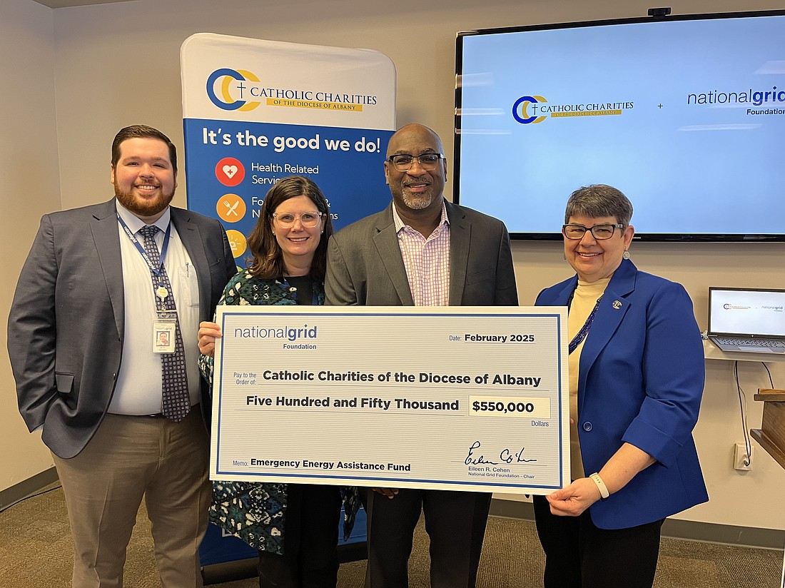 Seth Browe (l.) and Kimberly Ireland from National Grid, Robert Simmons, executive director of the National Grid Foundation, and Sister Betsy Van Deusen, CSJ, CEO of Catholic Charities of Albany, present a check for $550,000 to Catholic Charities Emergency Energy Assistance Fund. (Emily Benson photo)