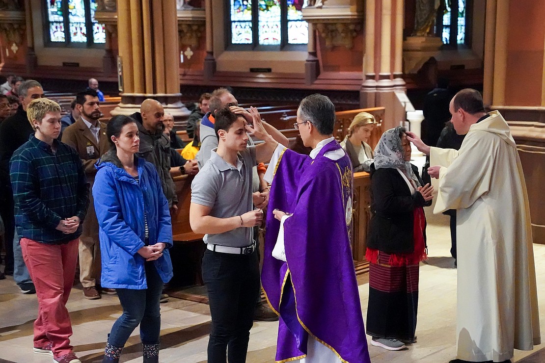 Father Rendell Torres places ashes on a parishioner’s forehead  during Ash Wednesday Mass on March 5 at the Cathedral of the Immaculate Conception in Albany. (Cindy Schultz photo for The Evangelist)