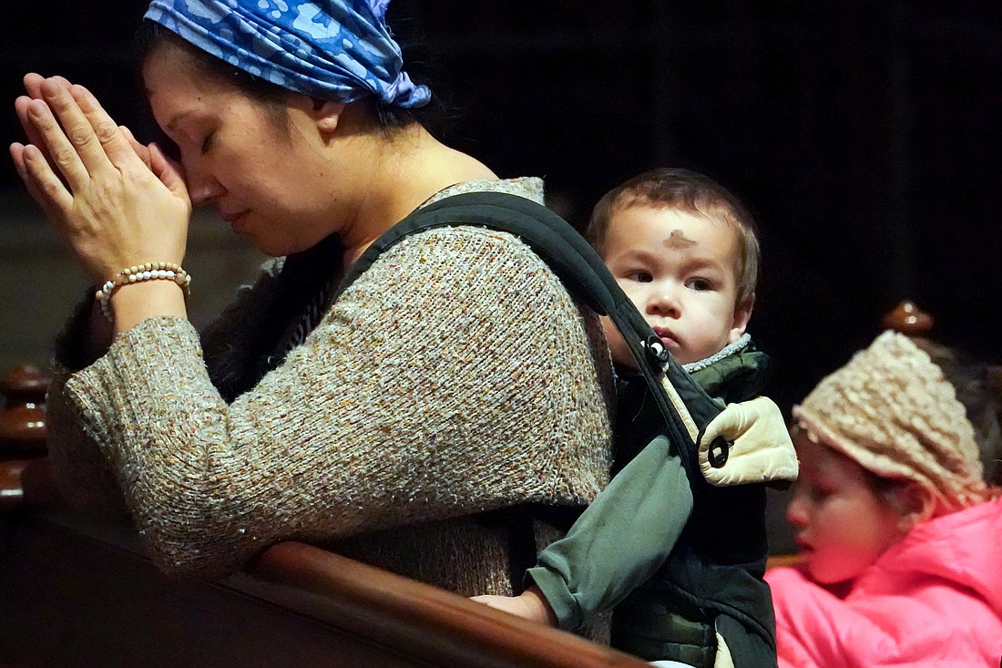 Cheryl DePra of Albany prays after she and her children receive ashes  during Ash Wednesday Mass on March 5 at the Cathedral of the Immaculate Conception in Albany. (Cindy Schultz photo for The Evangelist)