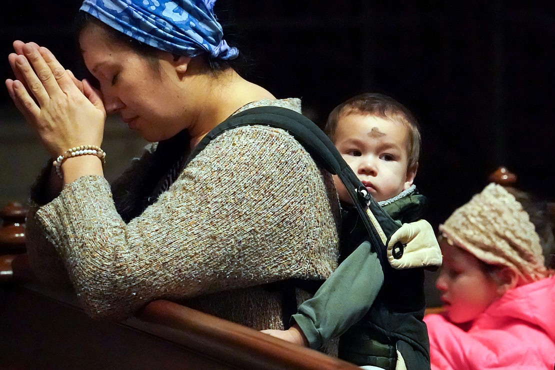 Cheryl DePra of Albany prays after she and her children receive ashes  during Ash Wednesday Mass on March 5 at the Cathedral of the Immaculate Conception in Albany. (Cindy Schultz photo for The Evangelist)