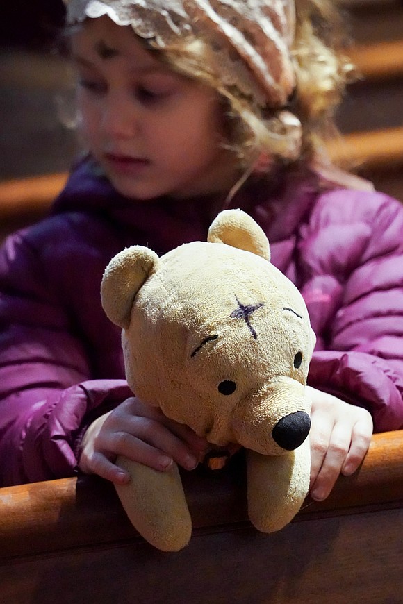 Winnie-the-Pooh also receives ashes along with Cheryl DePra (not pictured) and her children  during Ash Wednesday Mass on March 5 at the Cathedral of the Immaculate Conception in Albany. (Cindy Schultz photo for The Evangelist)