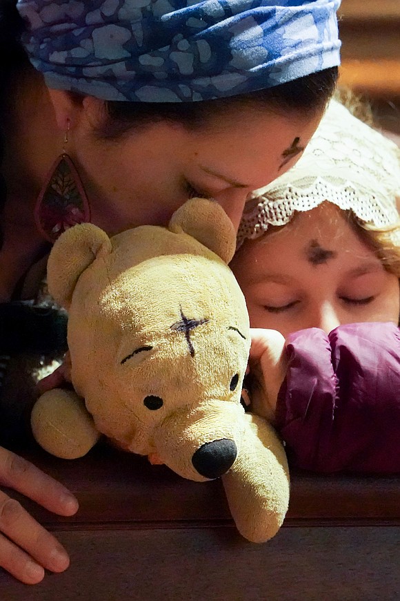 Winnie-the-Pooh also receives ashes along with Cheryl DePra of Albany (l.) and her children during Ash Wednesday Mass on March 5 at the Cathedral of the Immaculate Conception in Albany. (Cindy Schultz photo for The Evangelist)