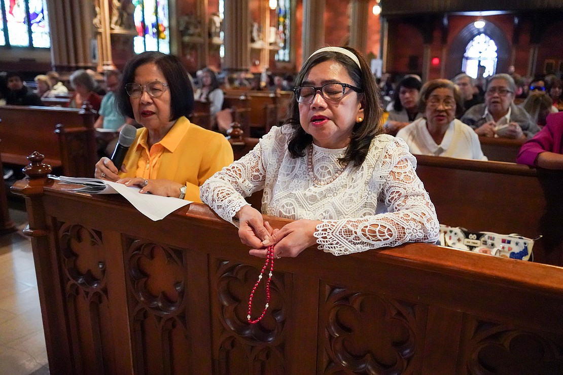 Leony Staples, left, and Merlinda Carmelino lead the Rosary before the Easter Mass on April 20 at the Cathedral of the Immaculate Conception in Albany. (Cindy Schultz photo for The Evangelist)