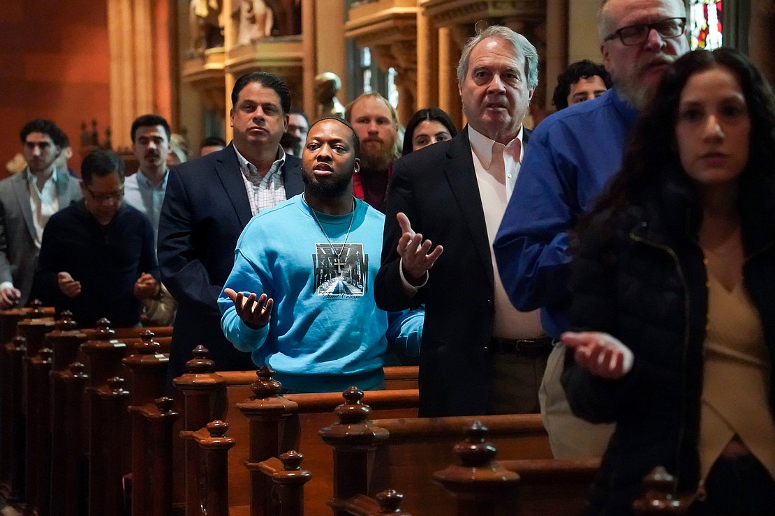 Ethan Selly-Yamie, center in blue, joins the congregation in the Lord’s Prayer during Easter Mass on April 20 at the Cathedral of the Immaculate Conception in Albany. (Cindy Schultz photo for The Evangelist)
