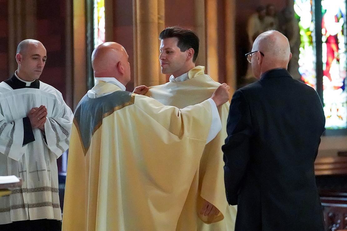 Alexander Turpin, center, candidate for deacon, is vested with stole and chasuble during his Ordination to the Diaconate on May 17 at the Cathedral of the Immaculate Conception in Albany. (Cindy Schultz for The Evangelist)