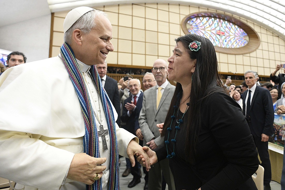 Paola Ugaz, a Peruvian journalist who helped expose the abuse committed by leaders of the Sodalitium Christianae Vitae, gives Pope Leo XIV a stole made of alpaca wool, during the pope's meeting with members of the media on May 12.  Ugaz, an abuse survivor, said then-Bishop Prevost “had supported us quietly -- not in front of the cameras -- since 2018. He never did it for recognition. He just helped. He was always there.” (CNS photo/Vatican Media)