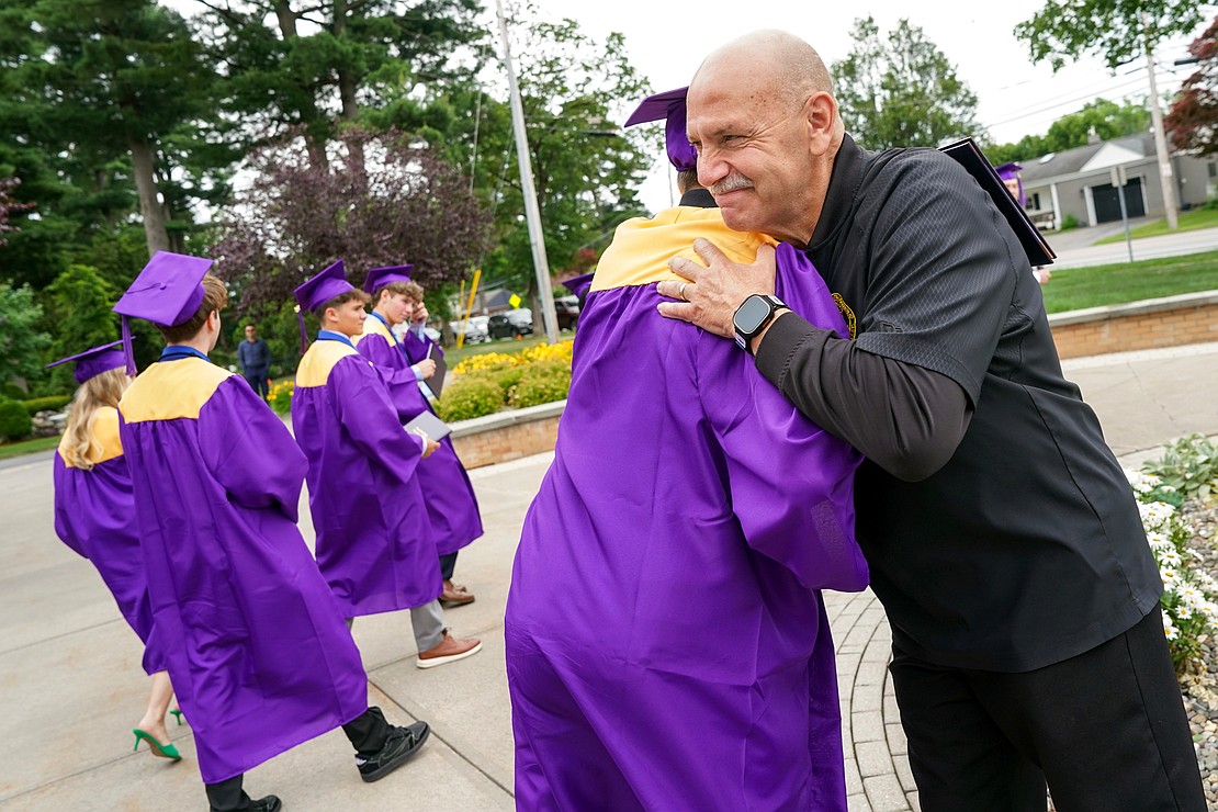 School safety monitor Chris Clark, right, embraces graduates following Saratoga Catholic Central’s commencement exercises on Friday June 27, 2024, at St. Clement’s Church in Saratoga Springs, N.Y.  Cindy Schultz for The Evangelist