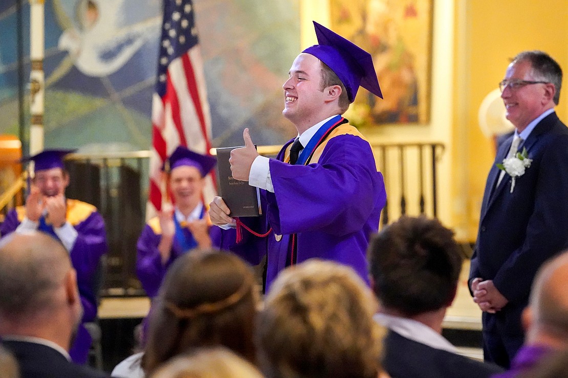 Graduate James Comstock, center, holds up his diploma for everyone to see during Saratoga Catholic Central’s commencement exercises on Friday June 27, 2024, at St. Clement’s Church in Saratoga Springs, N.Y.  Cindy Schultz for The Evangelist