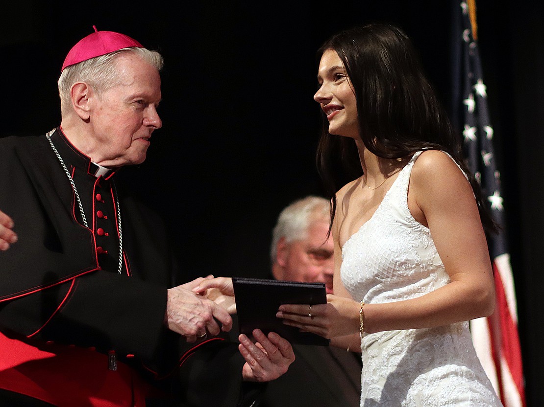 Carlie Cole receives her diploma from Bishop Edward B. Scharfenberger during Catholic Central's 102nd Commencement on June 7 at Russell Sage College in Troy. (Tom Killips photo)