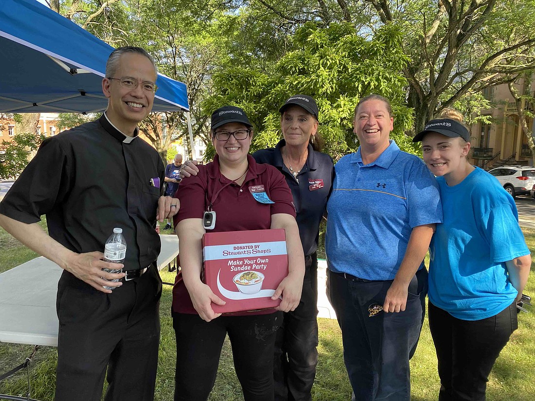 Father Rendell Torres (l.), rector of the Cathedral of the Immaculate Conception, inspired by the diocesan Remade for Mission initiative, decided to hold an ice cream social for the community at Bleecker Park on July 2 in Albany. (Kathy Barrans photo)