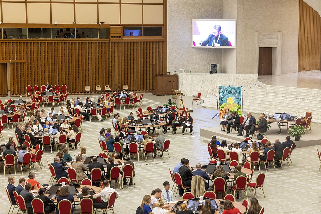 Bishop Daniel E. Flores of Brownsville, Texas, seated on stage and seen on a large screen, responds to questions from U.S. university students about the Synod of Bishops in the Paul VI Audience Hall at the Vatican Oct. 18, 2024. (CNS photo/Pablo Esparza)