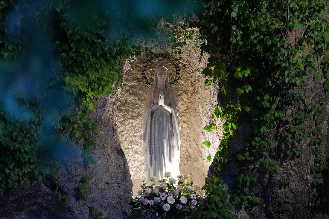 A statue of Mary, placed within a replica of the grotto in Lourdes, France, at the Vatican Gardens, is seen as Pope Leo XIV leads nighttime prayers to conclude the month of May, traditionally dedicated to Mary, May 31, 2025. (CNS photo/Lola Gomez)