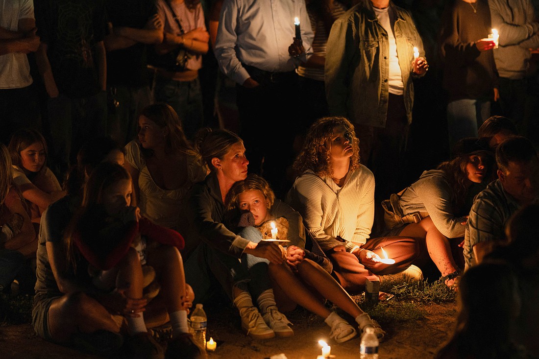 A girl sits in her mother's lap as mourners attend a vigil at Lynnhurst Park in Minneapolis Aug. 27, 2025, following a shooting earlier in the day at Annunciation Church. A shooter opened fire with a rifle through the windows of the school's church and struck children attending Mass during the first week of school, killing two and wounding 17 people in an act of violence the police chief called "absolutely incomprehensible." (OSV News photo/Tim Evans, Reuters)