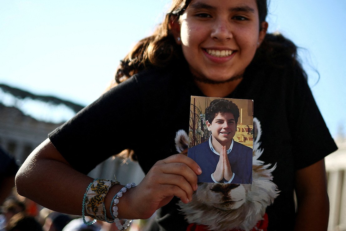 A young woman holds a picture of Blessed Carlo Acutis on the day Pope Leo XIV leads  the canonization Mass of Acutis, a British-born Italian boy who will become the first millennial to be made a Catholic saint, and Blessed Pier Giorgio Frassati, in St. Peter's Square at the Vatican, Sept. 7, 2025. (OSV News photo/Guglielmo Mangiapane, Reuters)