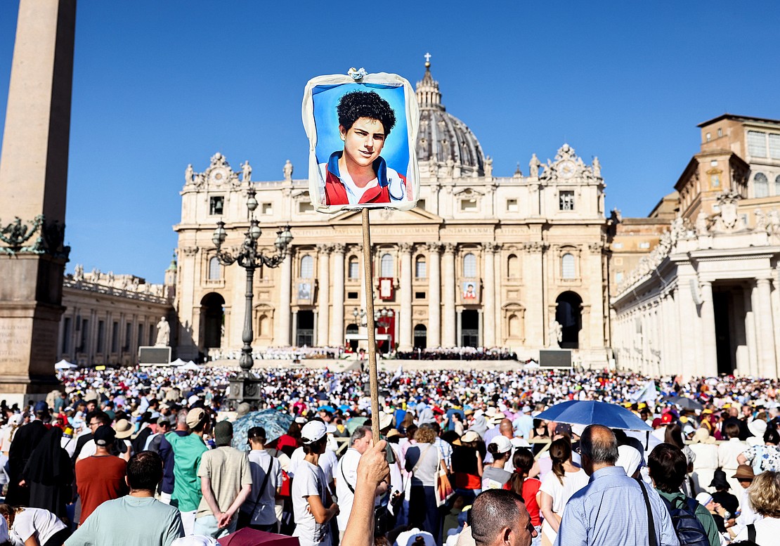 A person holds up an artwork on the day Pope Leo XIV leads  the canonization Mass of Blessed Carlo Acutis, a British-born Italian boy who will become the first millennial to be made a Catholic saint, and Blessed Pier Giorgio Frassati, in St. Peter's Square at the Vatican, Sept. 7, 2025. (OSV News/Matteo Minnella, Reuters)