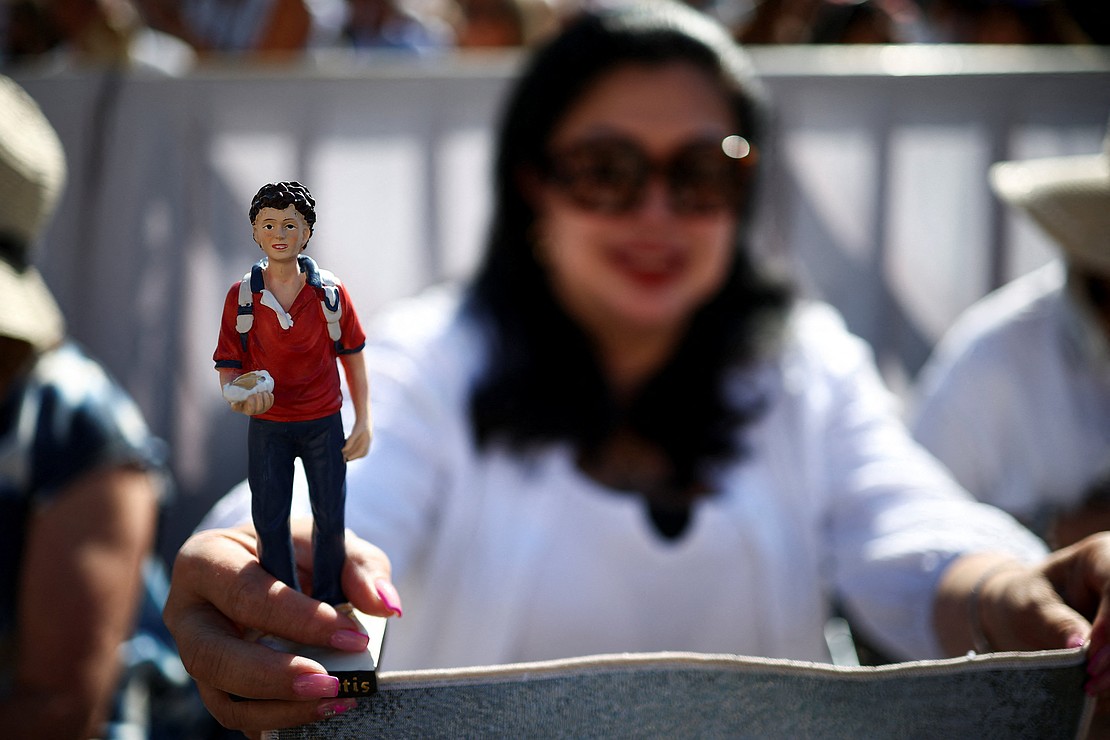 A woman holds a figure depicting Blessed Carlo Acutis on the day Pope Leo XIV leads  the canonization Mass of Acutis, a British-born Italian boy who will become the first millennial to be made a Catholic saint, and Blessed Pier Giorgio Frassati, in St. Peter's Square at the Vatican, Sept. 7, 2025. (OSV News photo/Guglielmo Mangiapane, Reuters)