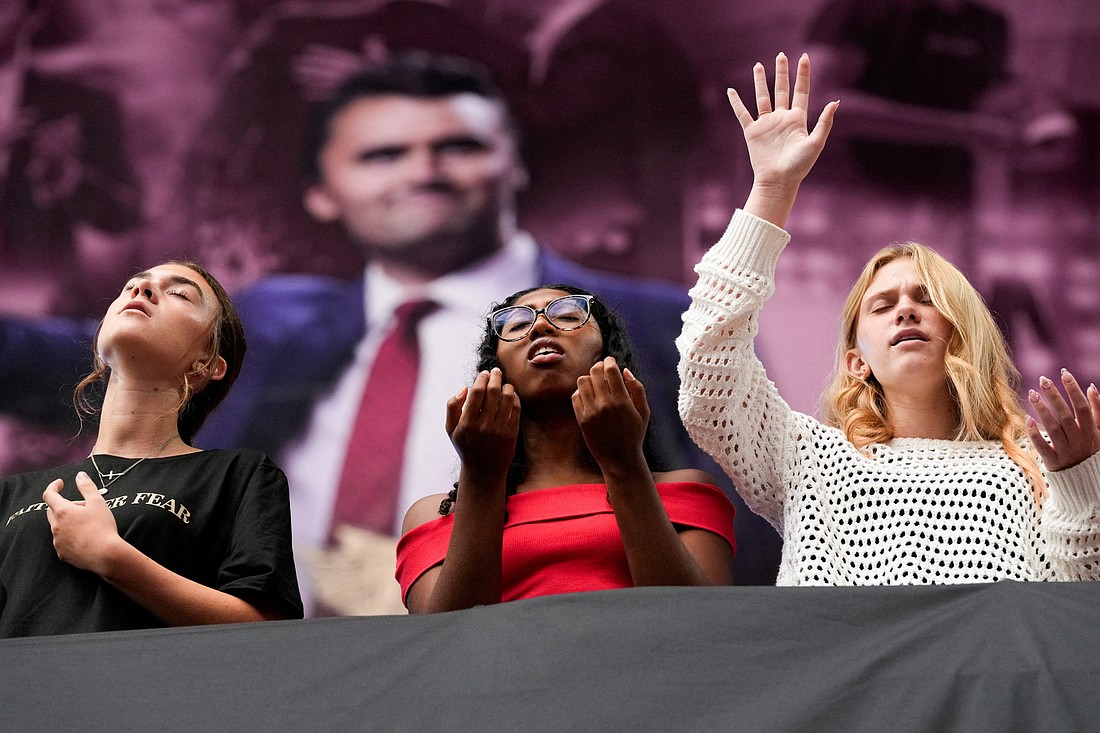 Young women pray as thousands gather at a memorial service for slain conservative activist Charlie Kirk at State Farm Stadium in Glendale, Ariz., Sept. 21, 2025. Kirk, founder of Turning Point USA, was fatally shot Sept. 10 during an event at Utah Valley University in Orem. (OSV News photo/Cheney Orr, Reuters)