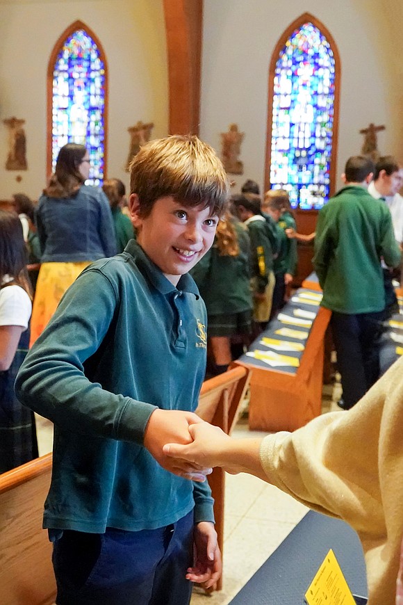 Fourth-grader Tommy Schuster practices showing a sign of peace during Mass on Sept. 11 at St. Thomas the Apostle Church in Delmar. (Cindy Schultz photo for The Evangelist)