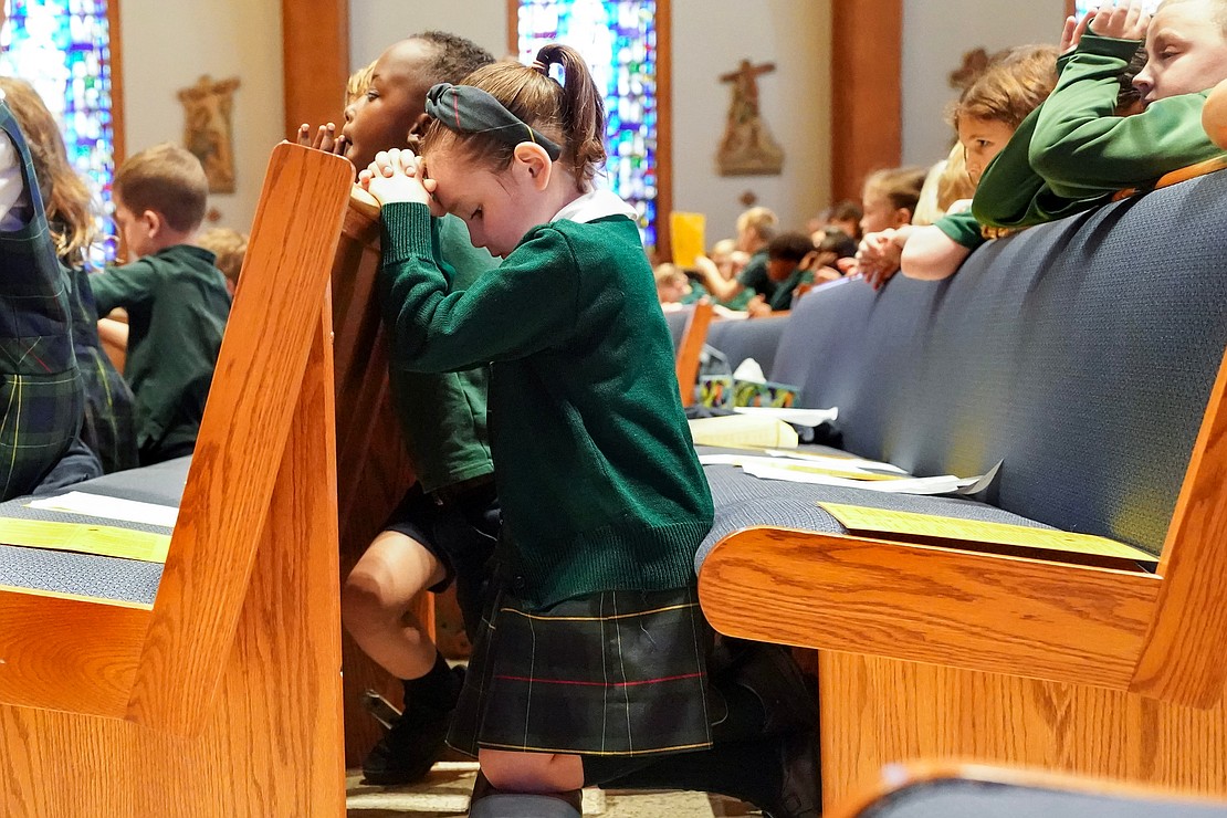 First-grader Nora Reilly kneels to pray during Mass on Sept. 11 at St. Thomas the Apostle Church in Delmar. (Cindy Schultz photo for The Evangelist)
