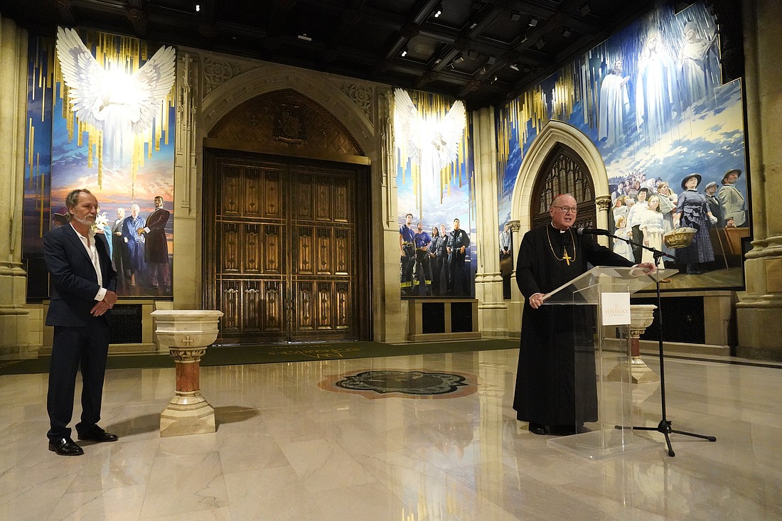 New York Cardinal Timothy M. Dolan speaks during the formal unveiling Sept. 18, 2025, of a 25-foot-high, four-panel mural in the narthex of St. Patrick's Cathedral in New York City. Looking on is artist Adam Cvijanovic, the mural's creator. The artwork depicts the 1879 Marian apparition in Knock, Ireland; people connected to the Catholic heritage and immigration history of the city of New York and the state; and first responders who serve the metropolitan area. (OSV News photo/Gregory A. Shemitz)